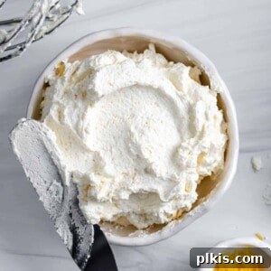 completed Lemon Buttercream Frosting in a white bowl against a white background