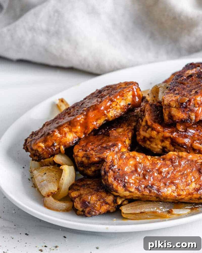 Sweet & Smoky Tempeh BBQ 14 Completed BBQ Tempeh plated on a white plate against a light background
