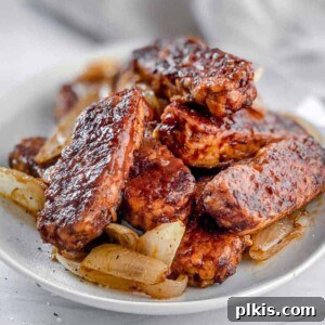 Sweet & Smoky Tempeh BBQ 16 Completed BBQ Tempeh plated on a white plate against a light background