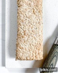 Raw block of tempeh on a white surface
