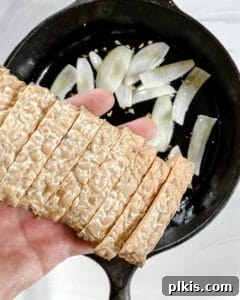 Process showing tempeh being added to the pan