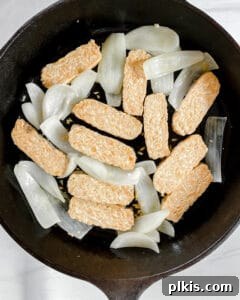 Process showing sliced tempeh and onions in a pan