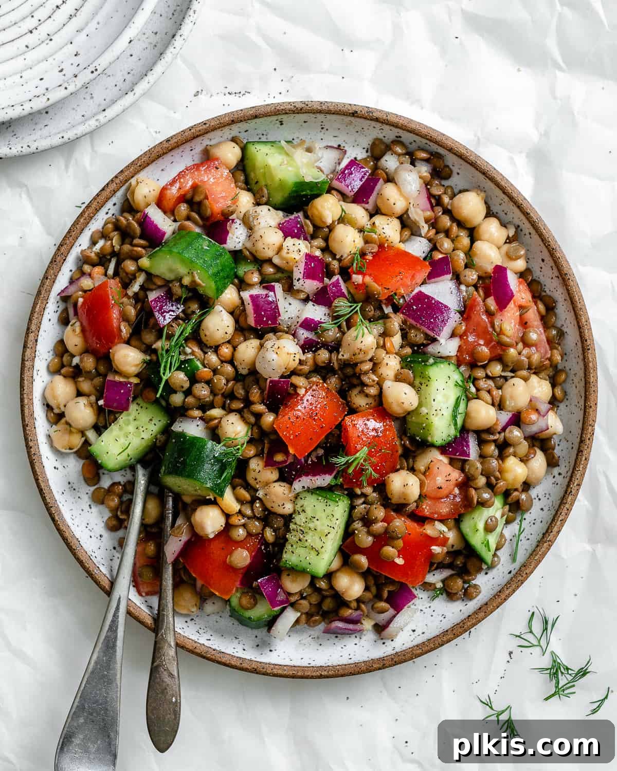completed Mediterranean Chickpea Salad [With Lentils] plated against a white background