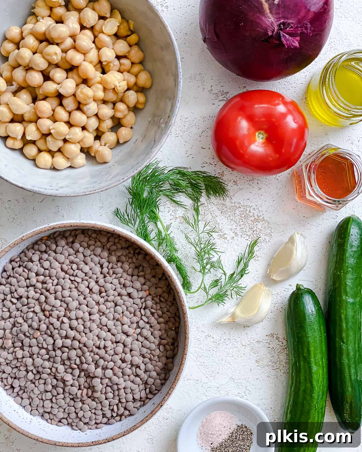 ingredients for Mediterranean Chickpea Salad [With Lentils] measured out against a white surface
