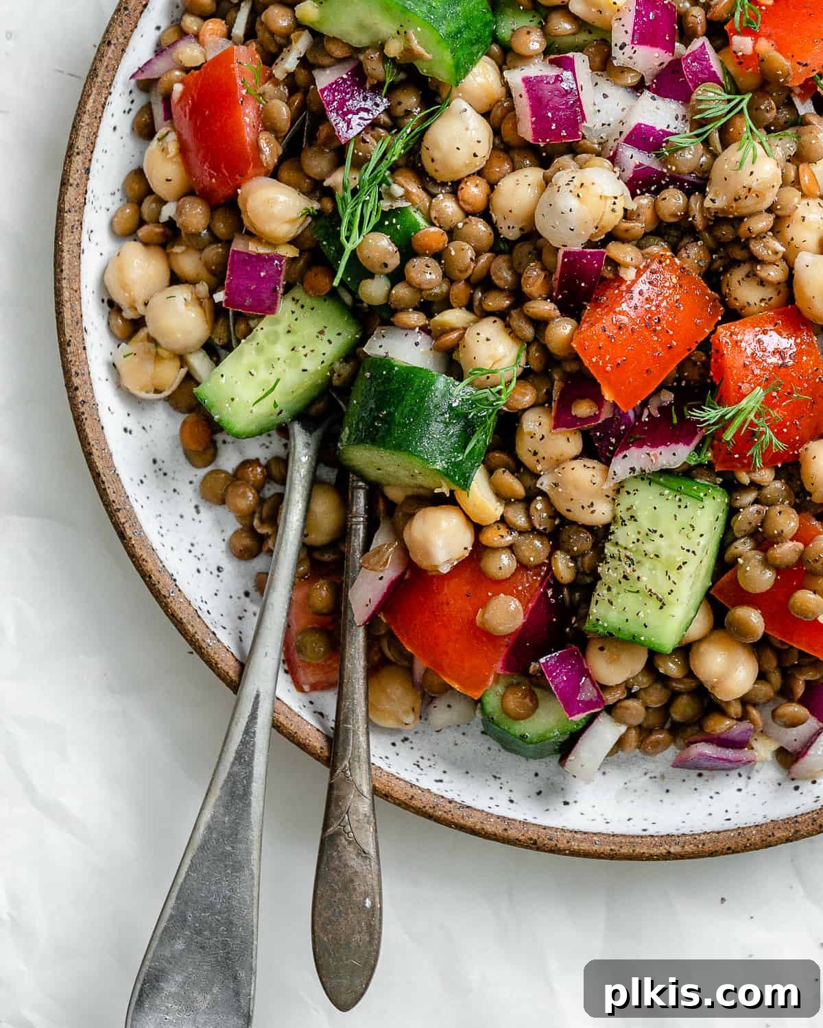 completed Mediterranean Chickpea Salad [With Lentils] plated against a white background