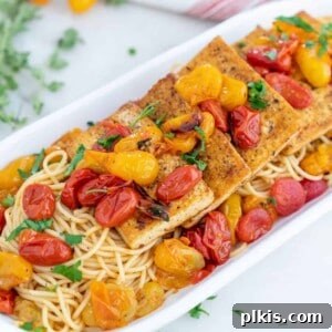 Crispy Tofu with Vibrant Tomato Herb Pan Sauce 4 completed Tofu Fillets with Tomato Herb Sauce in a white serving platter against a white background