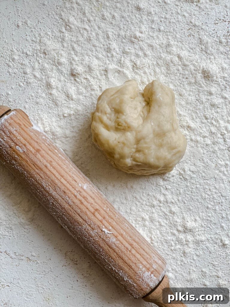 Handcrafted Flour Tortillas 11 Process shot showing a piece of dough alongside a rolling pin on a lightly floured surface.
