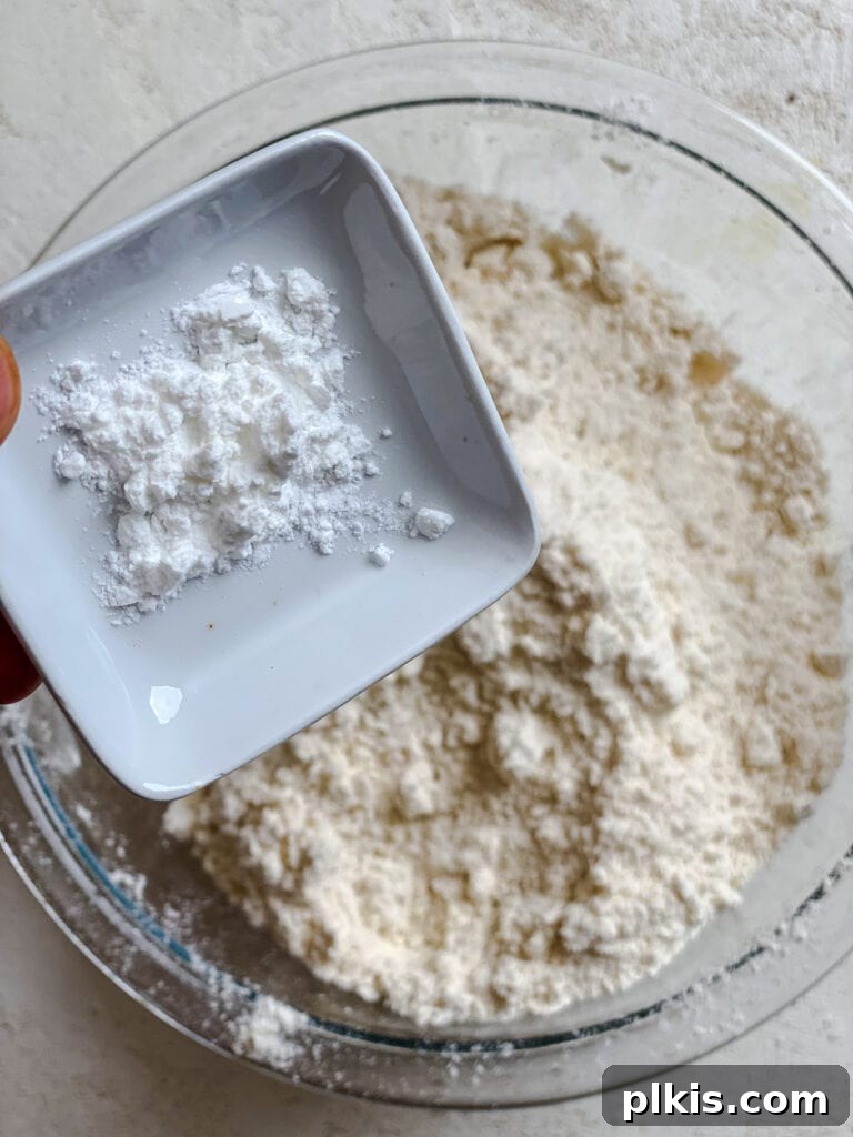 Handcrafted Flour Tortillas 5 Process shot of adding baking powder to the flour and butter mixture in a mixing bowl.
