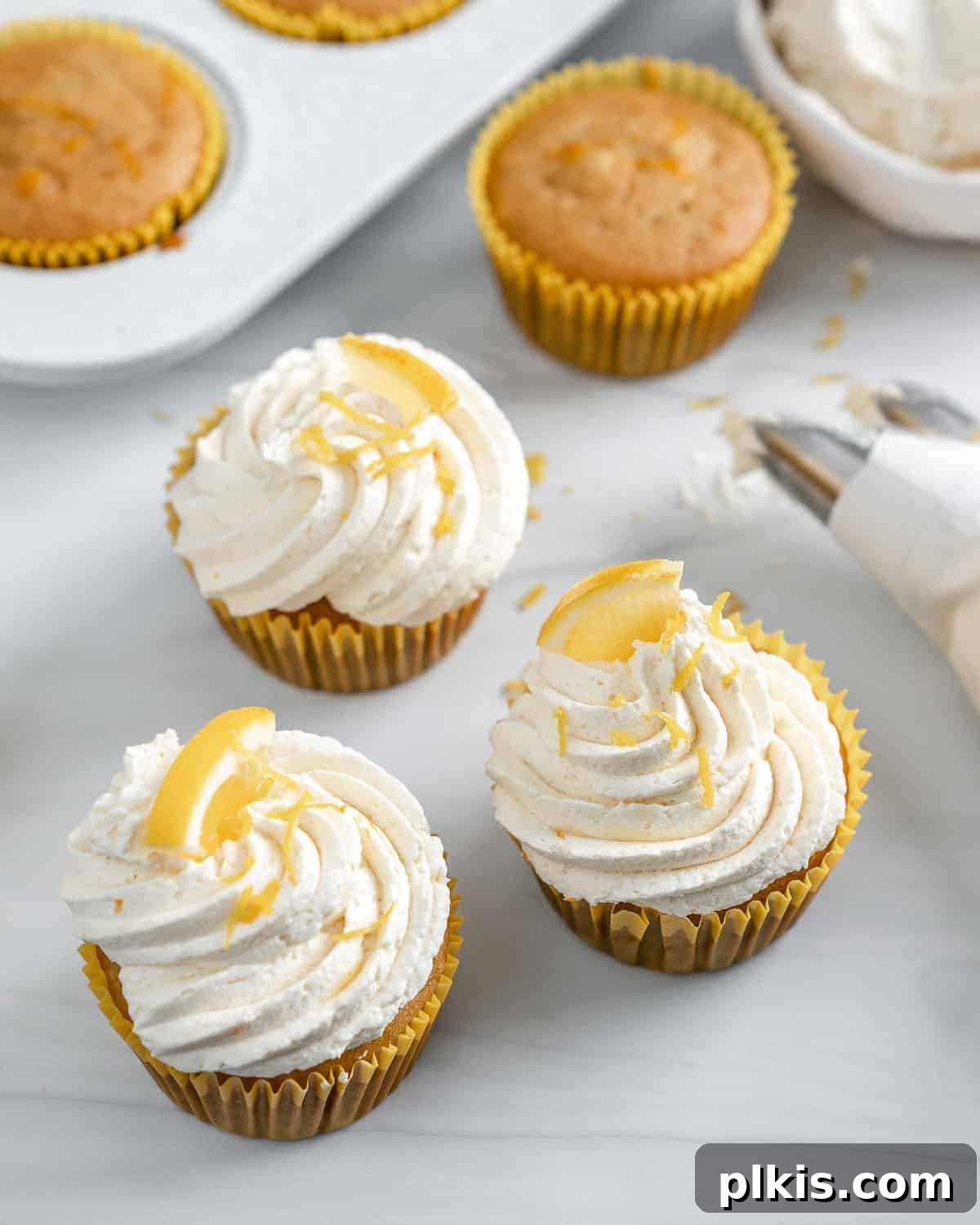 Effortless Vegan Lemon Cupcakes 2 Deliciously moist and zesty vegan lemon cupcakes with frosting, presented on a white surface.
