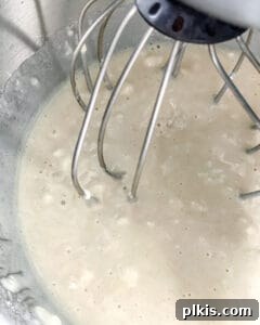 Effortless Vegan Lemon Cupcakes 4 Smooth, pale yellow lemon cupcake batter in a stainless steel mixing bowl, ready for baking.