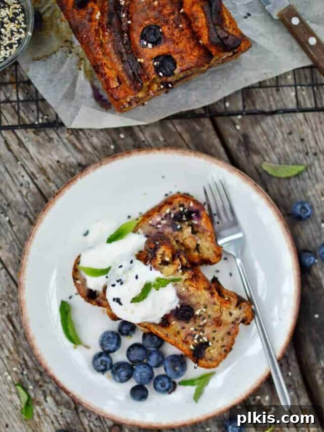 35 Irresistible Vegan Cake Creations 8 Two pieces of moist, delicious blueberry banana bread arranged on a white plate, set against a dark gray surface, inviting you to take a bite.