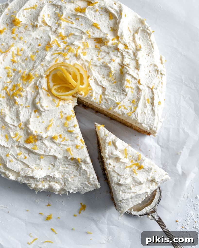 35 Irresistible Vegan Cake Creations 15 A beautifully glazed lemon cake, with a slice expertly cut and lifted on a cake slicer utensil, presented against a clean white background.