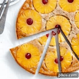 35 Irresistible Vegan Cake Creations 21 A beautiful vegan pineapple upside-down cake, perfectly sliced to reveal its caramelized fruit topping, set against a light background.