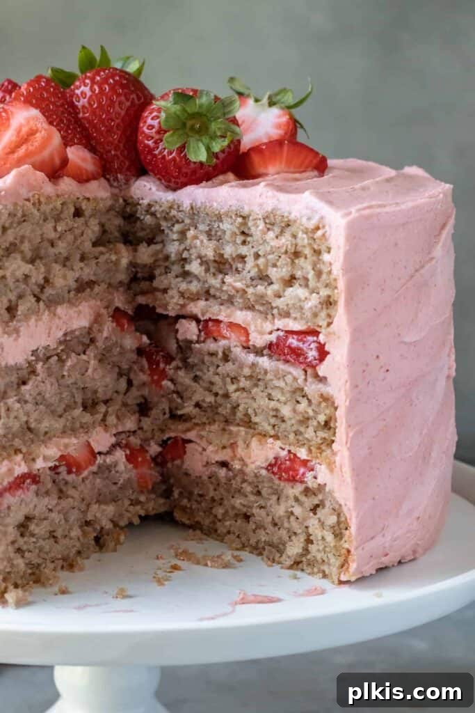 35 Irresistible Vegan Cake Creations 26 A stunning vegan strawberry cake with a slice removed, revealing its multiple delicious layers and fresh strawberry filling.