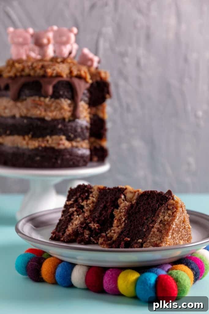 35 Irresistible Vegan Cake Creations 29 A stunning slice of vegan German chocolate cake, adorned with its rich filling and ganache, plated on a vibrant blue surface, with the full cake in the background.