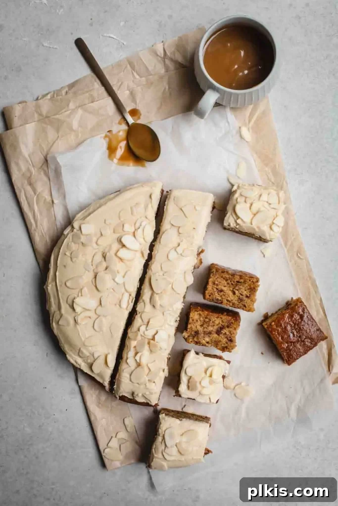 35 Irresistible Vegan Cake Creations 32 A delectable sticky date cake, with half of the cake expertly cut into square pieces, set against a light background with a cup of ingredients visible in the distance.