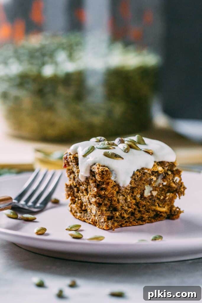 35 Irresistible Vegan Cake Creations 36 A perfectly portioned slice of rich vegan pumpkin cake with a creamy cashew glaze, elegantly plated on a white dish.