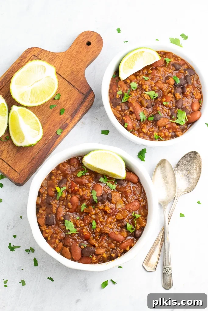 Over 30 Quick and Flavorful Vegan Instant Pot Recipes 18 completed vegan chili in two white bowls with a cutting board with lemons and utensils against a white background