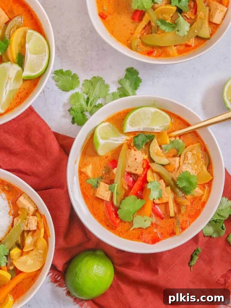 Over 30 Quick and Flavorful Vegan Instant Pot Recipes 20 completed Thai Panang Stew in several white bowls against a white surface with scattered herbs and a lemon and red towel