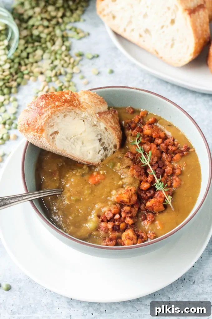 Over 30 Quick and Flavorful Vegan Instant Pot Recipes 5 completed vegan split pea soup in a white bowl with bread in the background against a white surface