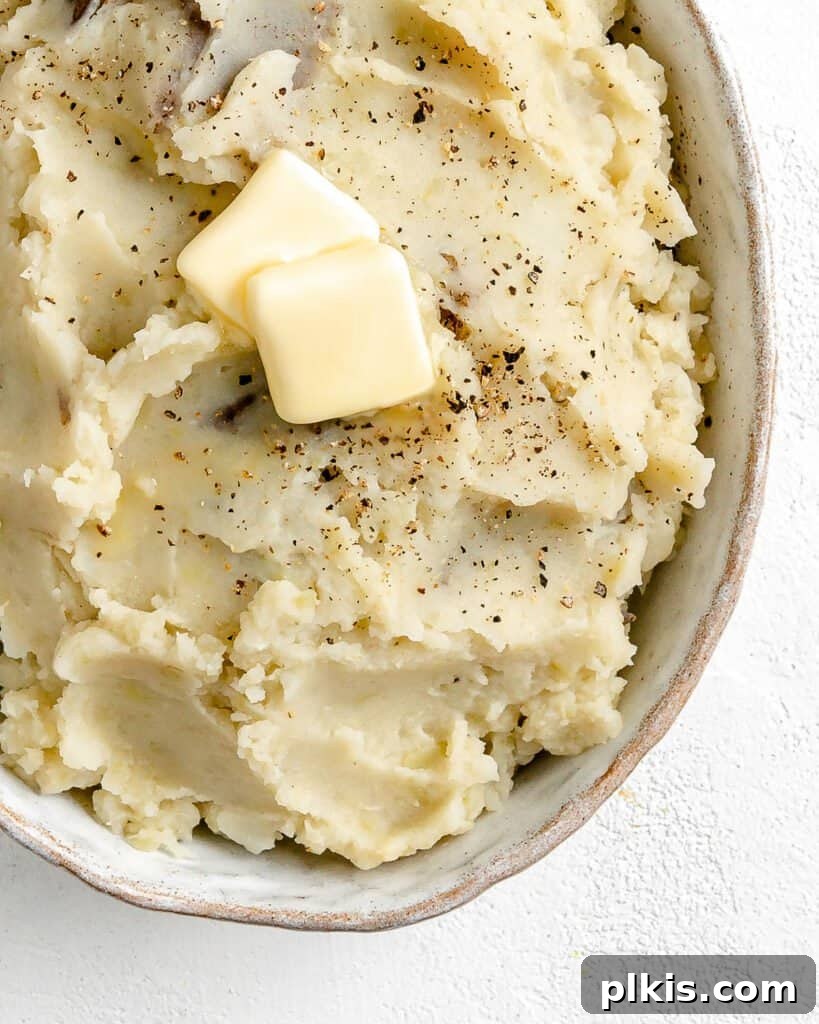 Over 30 Quick and Flavorful Vegan Instant Pot Recipes 32 completed Instant Pot Garlic Mashed Potatoes in a white serving dish against a white background