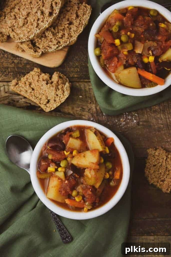 Over 30 Quick and Flavorful Vegan Instant Pot Recipes 7 completed instant pot veggie soup in a white bowl with bread in the background on a dark brown surface