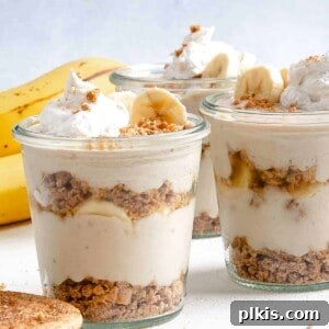 several completed banana parfait in glass jars against a white background