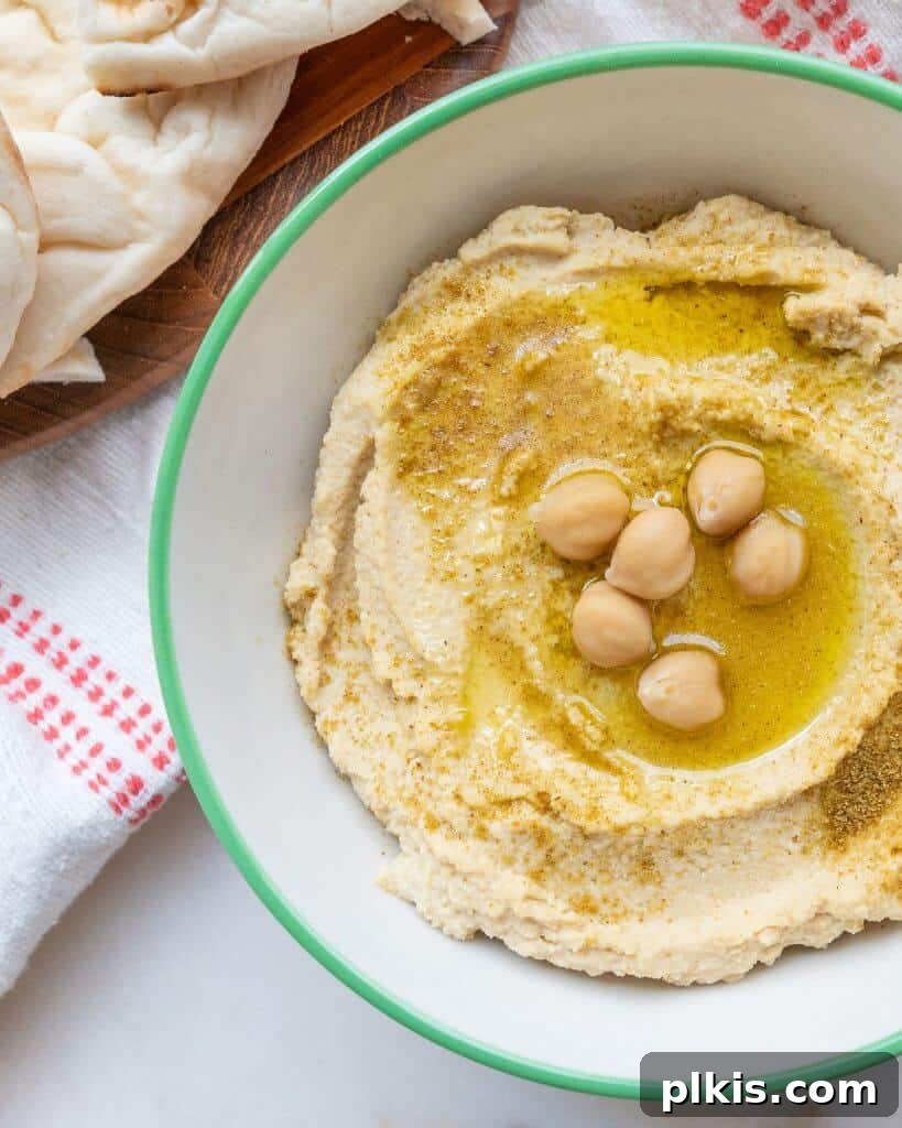 50 Quick Vegan Bites 12 A bowl of completed classic hummus, beautifully topped with a swirl of oil and whole chickpeas.