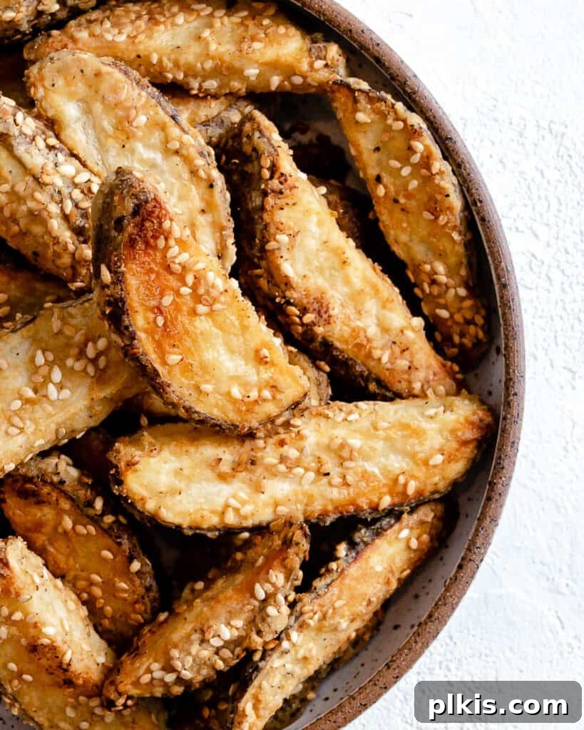 50 Quick Vegan Bites 27 Completed oven baked sesame fries served on a white plate against a clean white background.