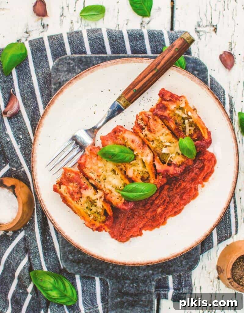 50 Quick Vegan Bites 60 Completed vegan stuffed shells beautifully plated on a white plate against a stylish gray and white towel.