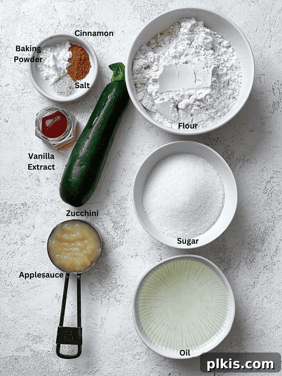 All the measured ingredients for Easy Vegan Zucchini Bread displayed on a clean white surface, ready for mixing.