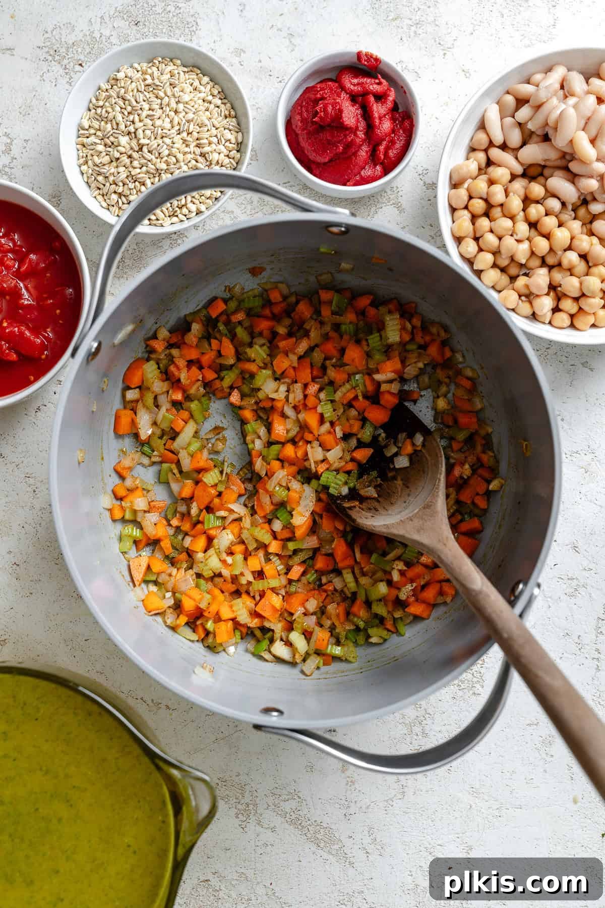 Hearty Barley and Bean Stew 5 Process shot showing stirring ingredients in a pot.
