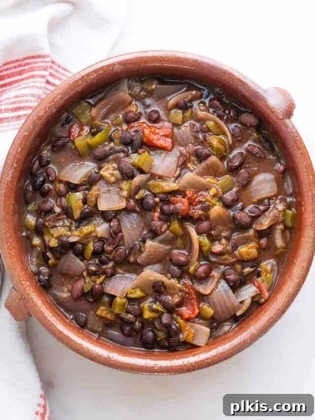 Quick & Delicious: 30-Minute Vegan Dinners 16 Completed black bean chili in an orange bowl against a white background.