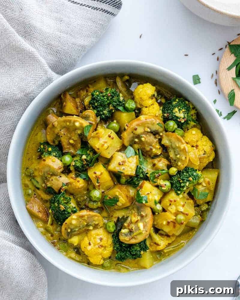 Quick & Delicious: 30-Minute Vegan Dinners 19 Perfect Potato and Pea Coconut Curry in a white bowl against a white background.