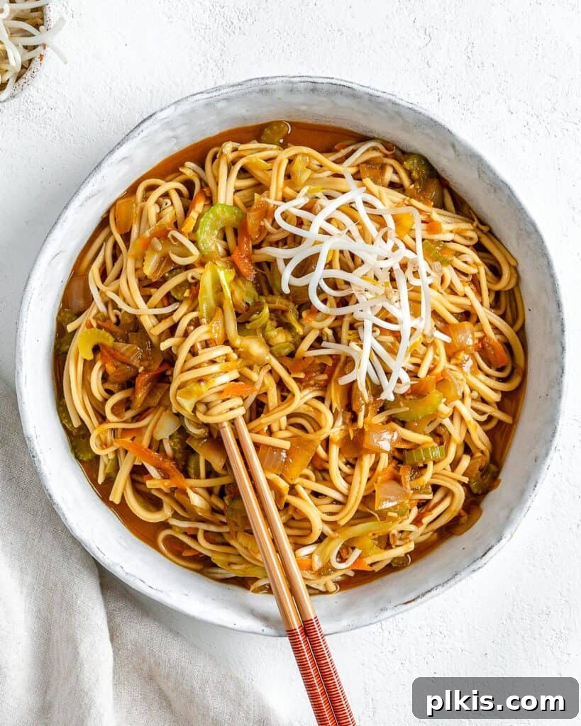 Quick & Delicious: 30-Minute Vegan Dinners 4 Completed bowl of Veggie Chow Mein in a white bowl against a white background with two chopsticks in the bowl.