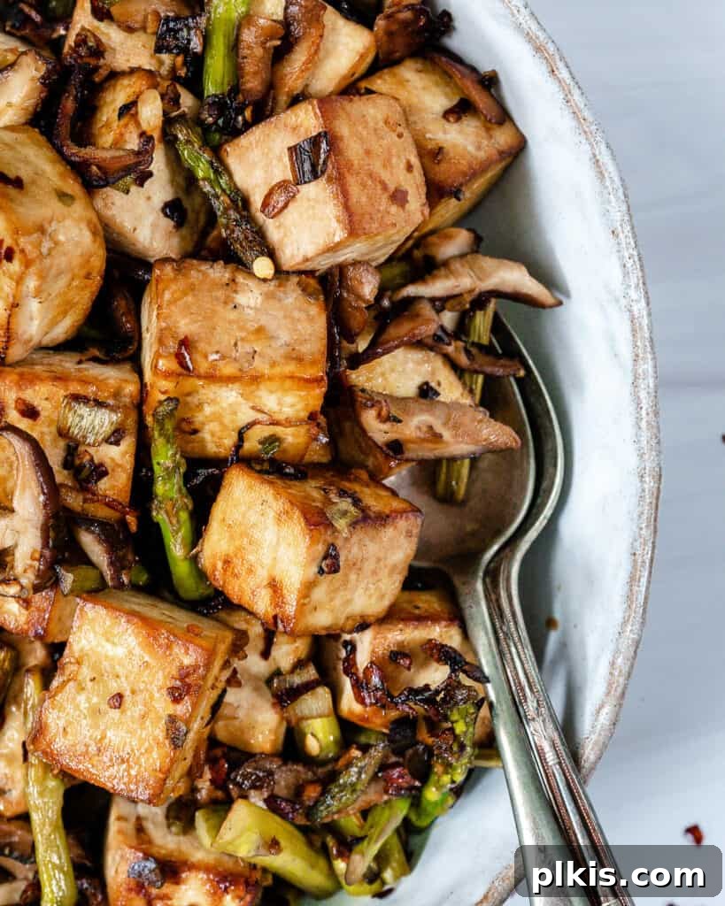 Quick & Delicious: 30-Minute Vegan Dinners 23 Finished Shiitake Asparagus Tofu Stir-fry plated on a white plate.