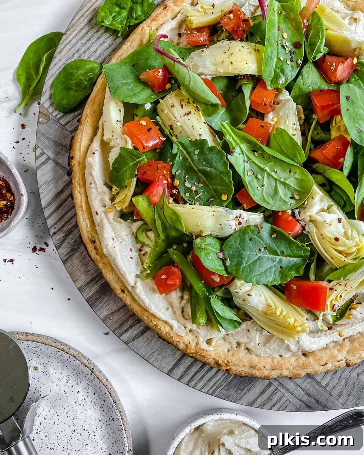 Quick & Delicious: 30-Minute Vegan Dinners 38 Completed hummus pizza sliced on a gray surface.