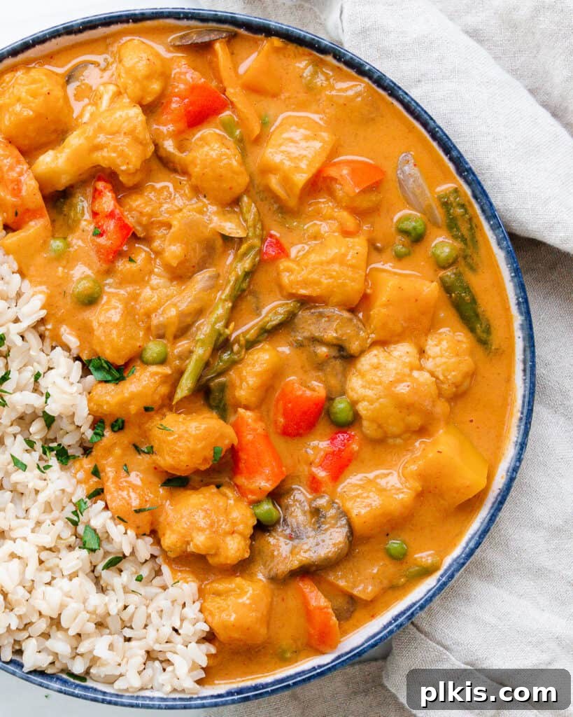 A comforting bowl of Butternut Squash Curry, rich in color and texture, set against a pristine white background.