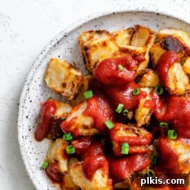 A plate of perfectly cooked Patatas Bravas, garnished and ready to serve.