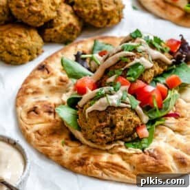 Healthy baked falafel served on bread, against a white background.