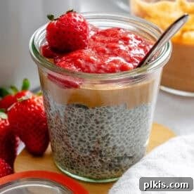 A jar of Peanut Butter Chia Pudding with a vibrant berry compote layer.