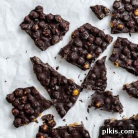 Chocolate Covered Chickpeas bark on a white surface.