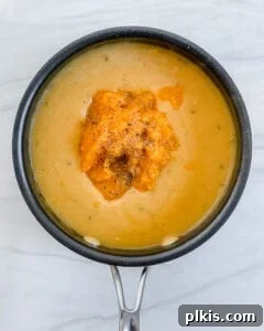 The finished, smooth, and creamy pumpkin sauce resting in a black pan, perfectly seasoned and ready for the pasta.