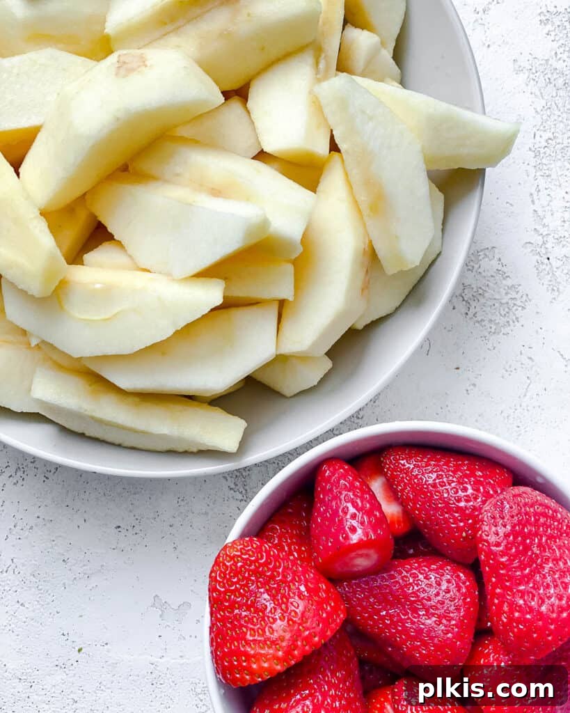 Blush Berry Apple Puree 7 sliced apples and strawberries in a white bowl against a white background