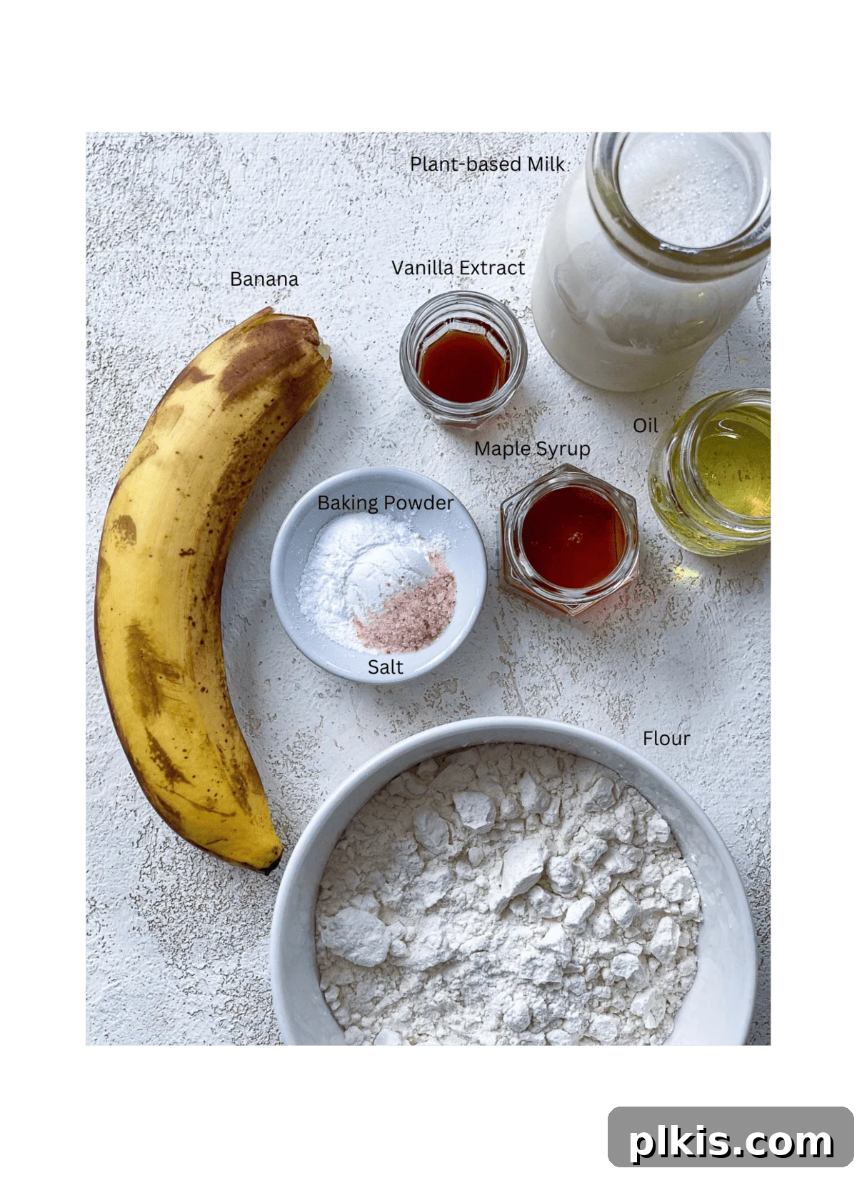 ingredients of banana pancakes spread out against a white surface