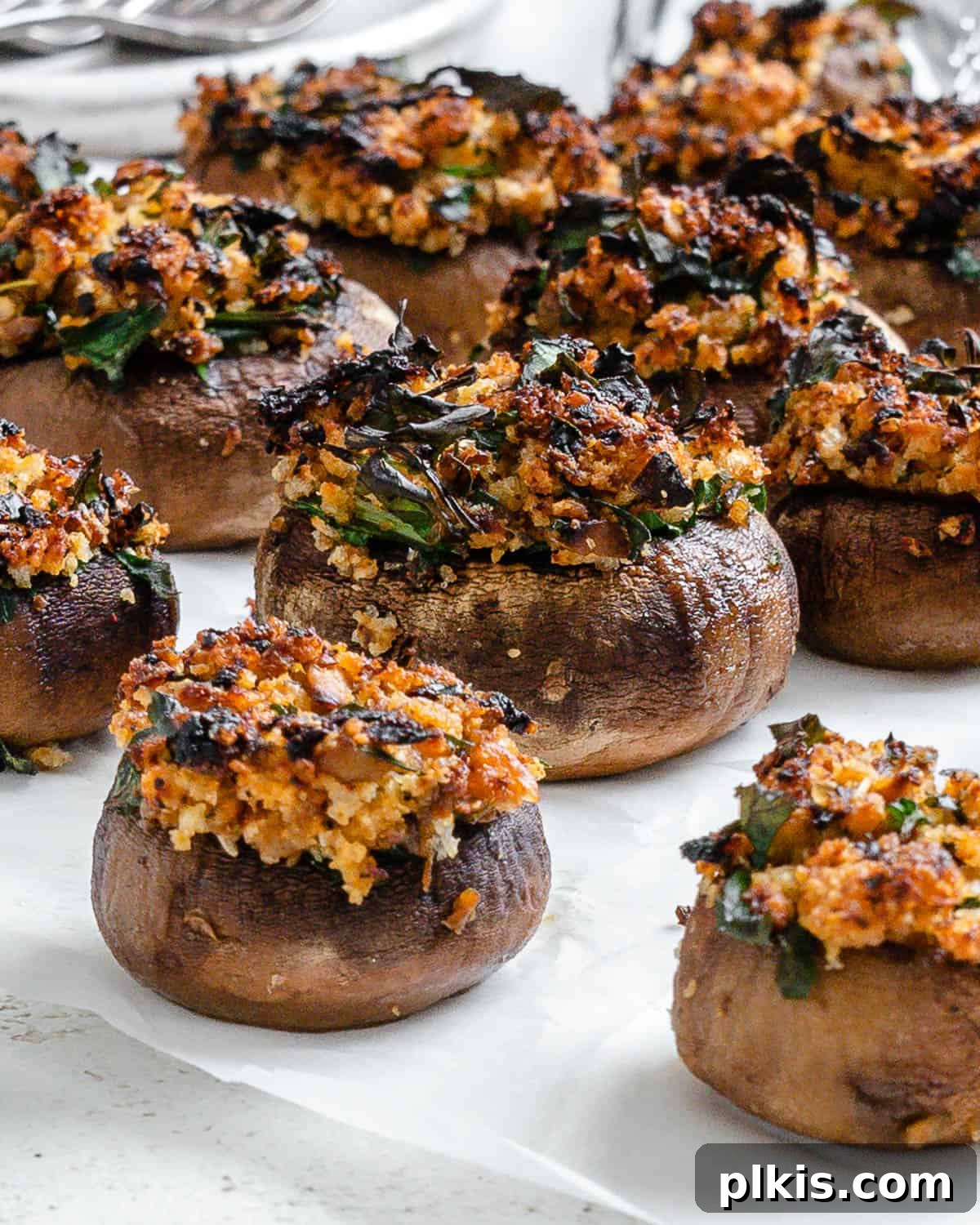 A serving of Easy Vegan Stuffed Mushrooms on a white plate, ready to be enjoyed, highlighting their golden brown tops.