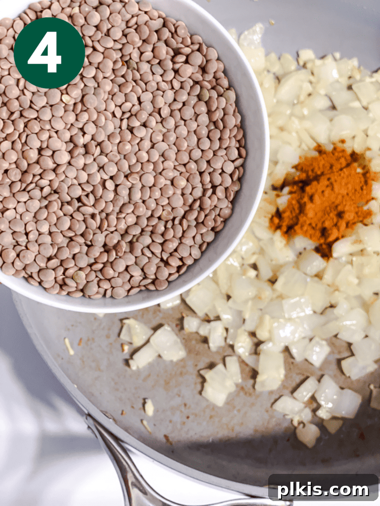 Effortlessly Delicious Curried Lentils 7 Process shot of adding uncooked lentils to the pan
