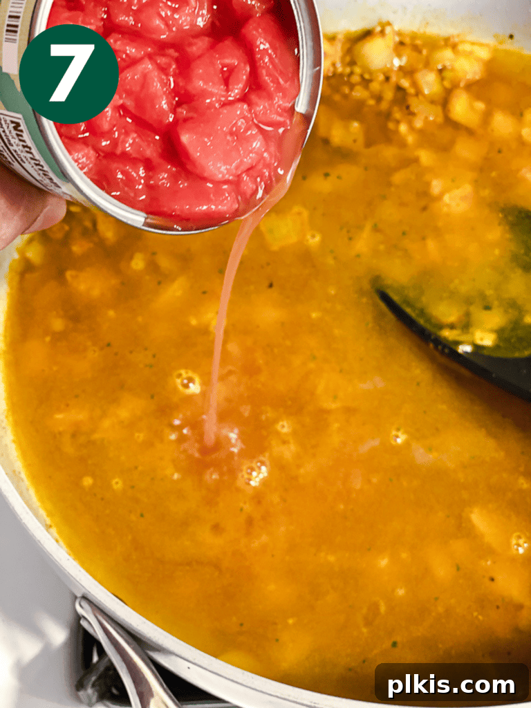 Effortlessly Delicious Curried Lentils 10 Process shot of adding diced tomatoes to the lentil curry