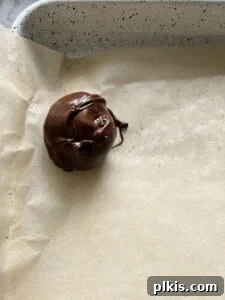 Crispy Vegan No-Bake Chocolate Peanut Butter Bites 8 process of placing a chocolate covered bon bon on parchment paper