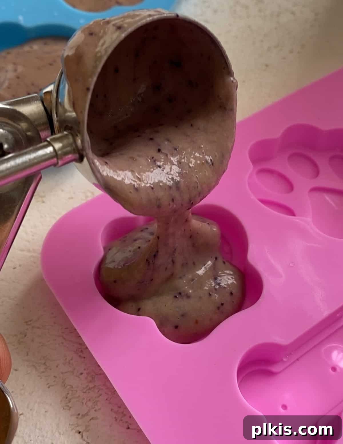 Frosty Peanut Butter Banana Puppy Snacks 9 The process of filling dog treat molds with the creamy banana mixture